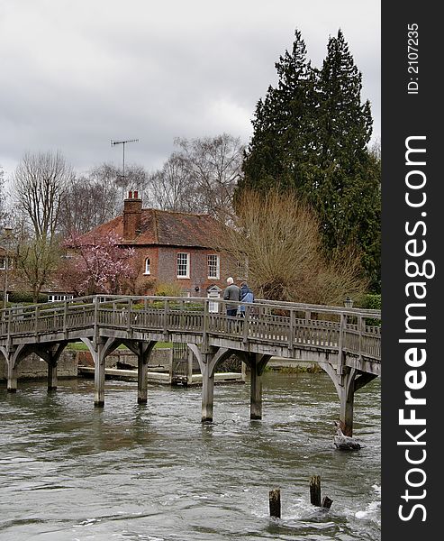 Wooden Footbridge over a Swollen River Thames in England  with people walking accross