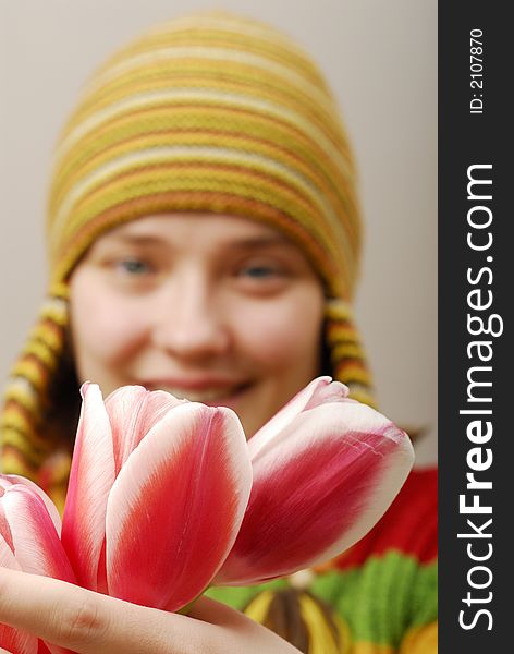 Buds of tulips and girl in yellow cap on background