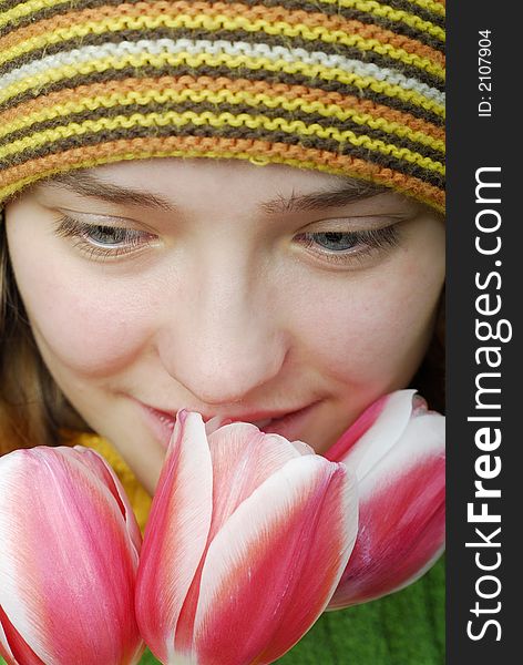 Girl in striped cap and face in pink tulips. Girl in striped cap and face in pink tulips.