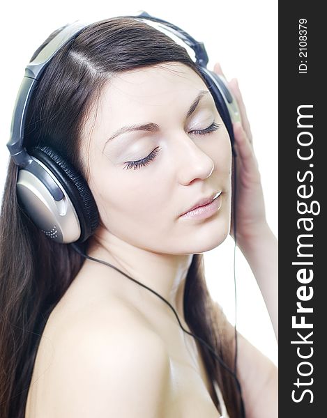 Brunette in headphones listens to music on a white background