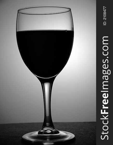 A black and white image of a glass of wine, taken in a studio. A black and white image of a glass of wine, taken in a studio.