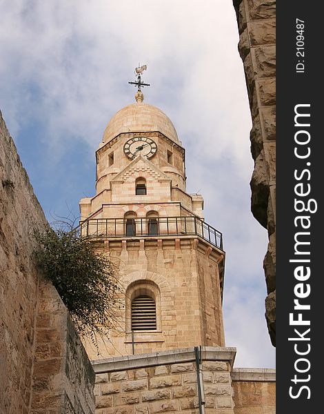 Dormition Abby (Benedictine Basilica of the Dormition) watch tower in Jerusalem. The Dormition Abbey is a massive structure, just outside the Zion Gate, and resembles a mighty fortress; it is topped by a high, domed belltower, a conical dome and corner towers. Dormition Abby (Benedictine Basilica of the Dormition) watch tower in Jerusalem. The Dormition Abbey is a massive structure, just outside the Zion Gate, and resembles a mighty fortress; it is topped by a high, domed belltower, a conical dome and corner towers.