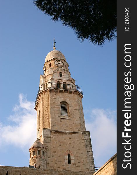 Dormition Abby (Benedictine Basilica of the Dormition) watch tower in Jerusalem. The Dormition Abbey is a massive structure, just outside the Zion Gate, and resembles a mighty fortress; it is topped by a high, domed belltower, a conical dome and corner towers. Dormition Abby (Benedictine Basilica of the Dormition) watch tower in Jerusalem. The Dormition Abbey is a massive structure, just outside the Zion Gate, and resembles a mighty fortress; it is topped by a high, domed belltower, a conical dome and corner towers.