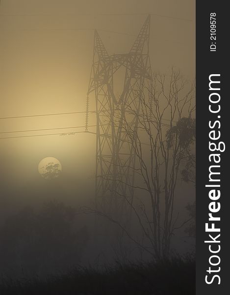 An electrical power pylon with powerlines is depicted in a foggy sunrise. An electrical power pylon with powerlines is depicted in a foggy sunrise.