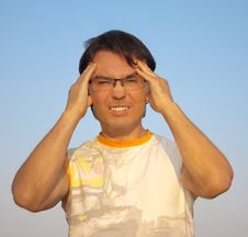 Young Man With A Headache Against Blue Sky Stock Photography Young Man With A Headache Against Blue Sky Stock Photography