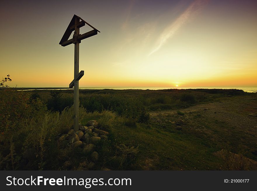 Old wooden cross on a sunset
