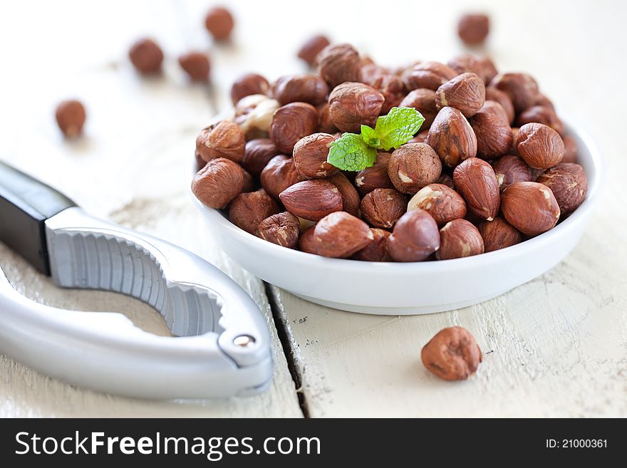 Fresh hazelnuts in bowl with nutcracker