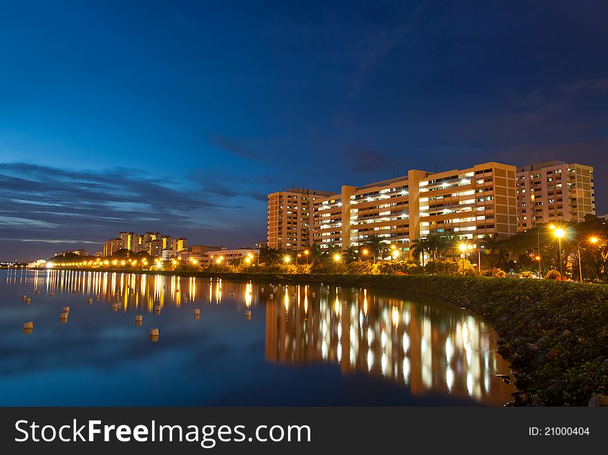 Night view of peaceful residential district with reflection in lake.