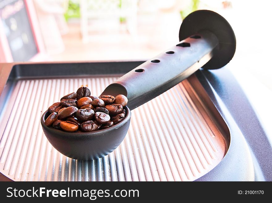 Coffee seed on spoon on coffee machine