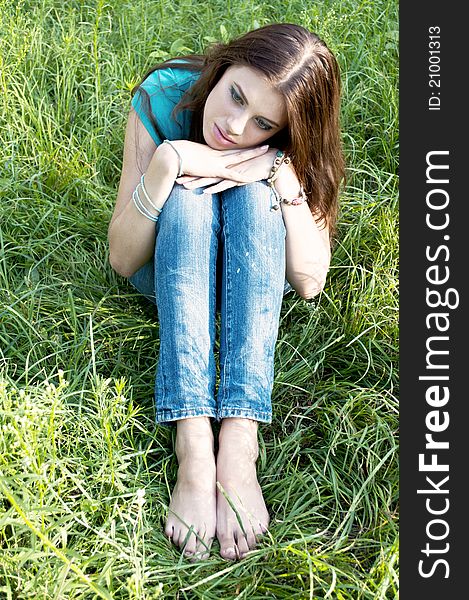 Beautiful girl in shorts sitting on the grass. Beautiful girl in shorts sitting on the grass.