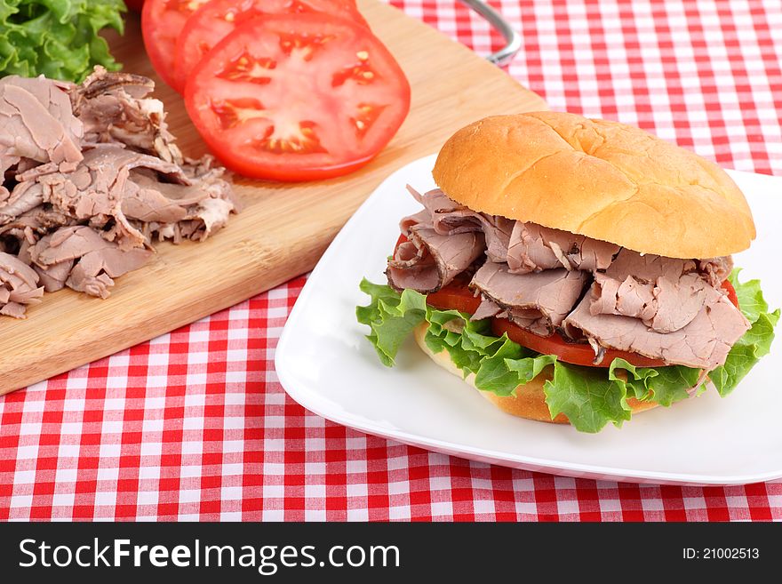 Roast beef sandwich with lettuce and tomato on a plate