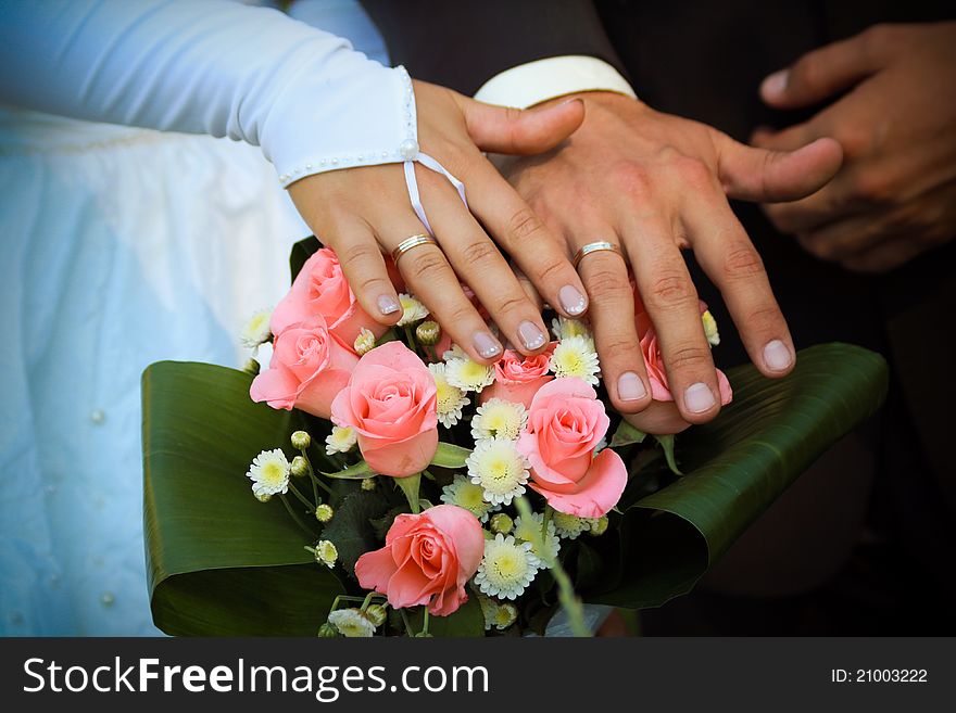 Bridegroom`s and bride`s arms with wedding rings. Bridegroom`s and bride`s arms with wedding rings