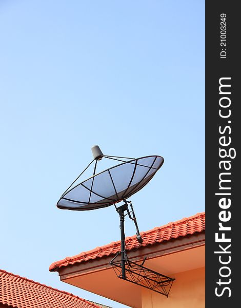 Satellite antenna on red roof.