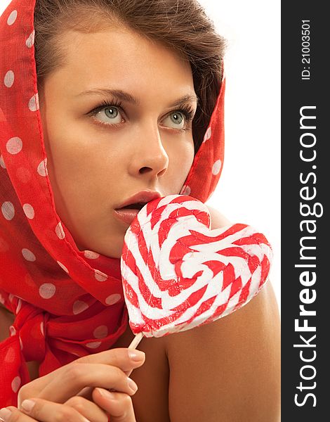 Close-up portrait of young woman with heart shaped lollipop