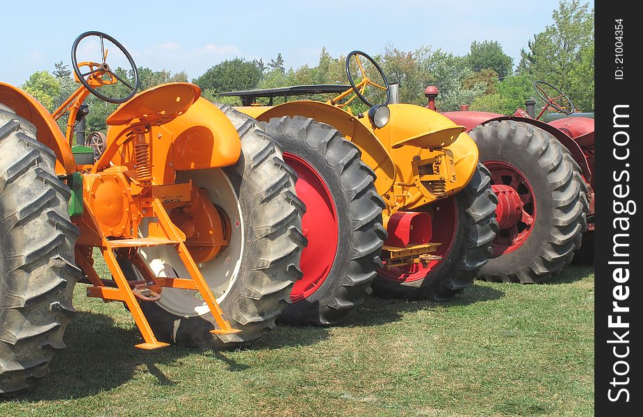 Three farm tractors from a rear view