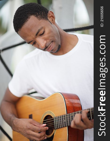 Image of a young black man playing his guitar. Image of a young black man playing his guitar