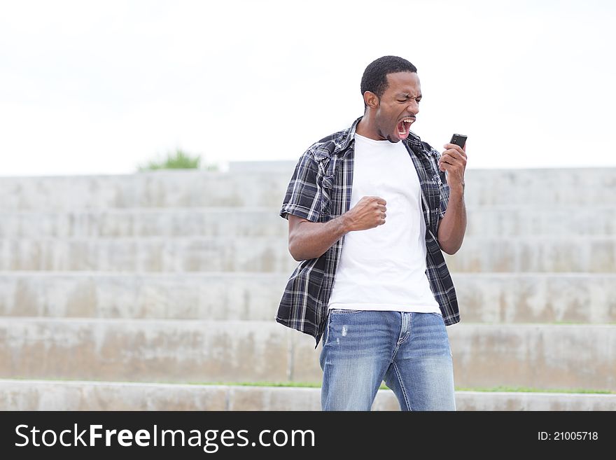 Young black man screaming at his cellphone