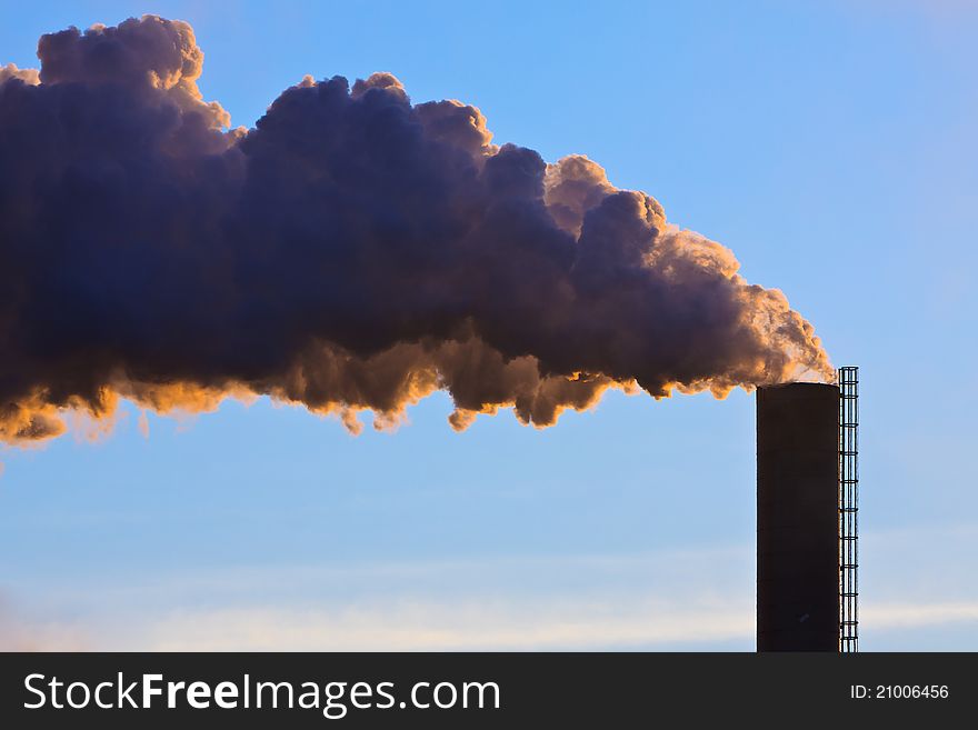 Industrial factory with smoking chimney at sunset. Industrial factory with smoking chimney at sunset