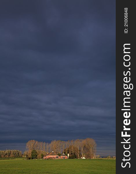 Landscape with grassland and farm on a rainy day