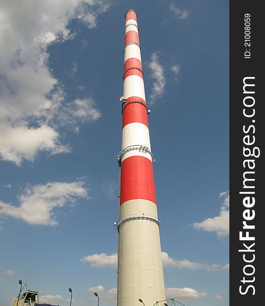 White and red high chimney against a blue sky