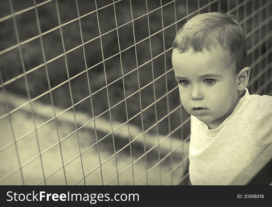 Urban child against the background of metal mesh. Urban child against the background of metal mesh