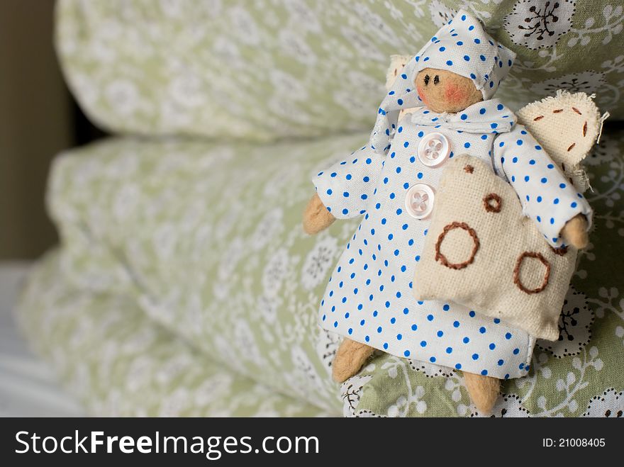 Handmade rag-doll with pillow in hand on pile of pillows. Handmade rag-doll with pillow in hand on pile of pillows