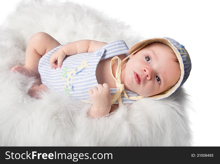 Baby boy lying in furry basket looks up