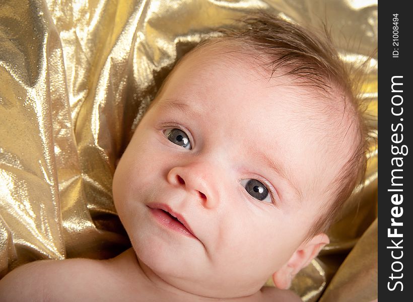 Closeup portrait of baby boy on gold background