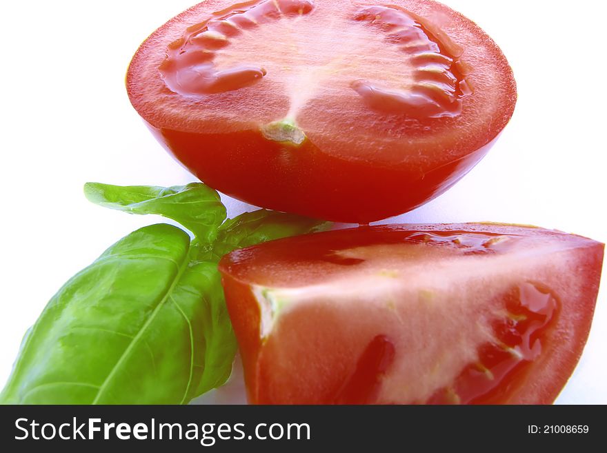 Red tomatoes with green basil on white background