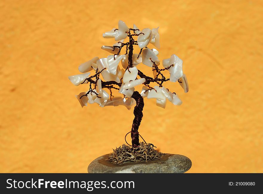 Tree made from metal and shells on orange background. Tree made from metal and shells on orange background