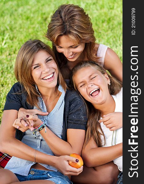 Happy mother with her daughters in park outdoors. Happy mother with her daughters in park outdoors