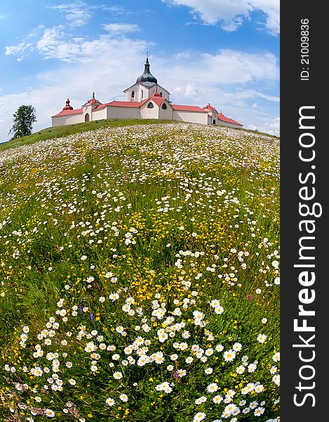 Baroque monastery above the meadow with daisy flowers. Baroque monastery above the meadow with daisy flowers