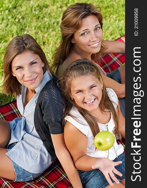 Happy mother with her daughters in park outdoors. Happy mother with her daughters in park outdoors