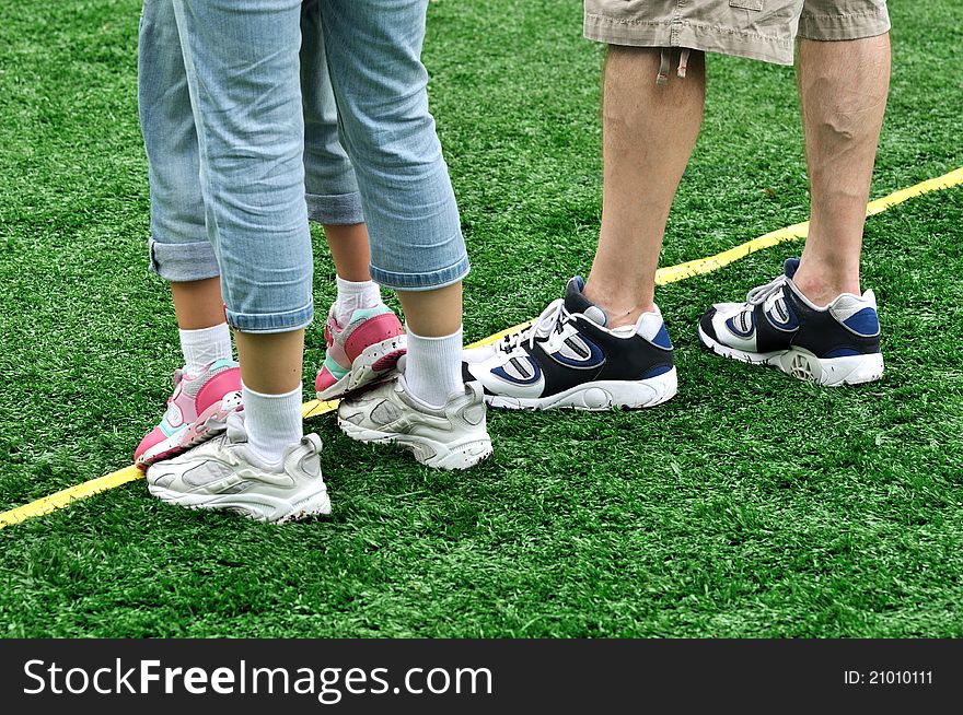 Feet of a family in game, shown as happy family enjoy game or holiday on grass land.