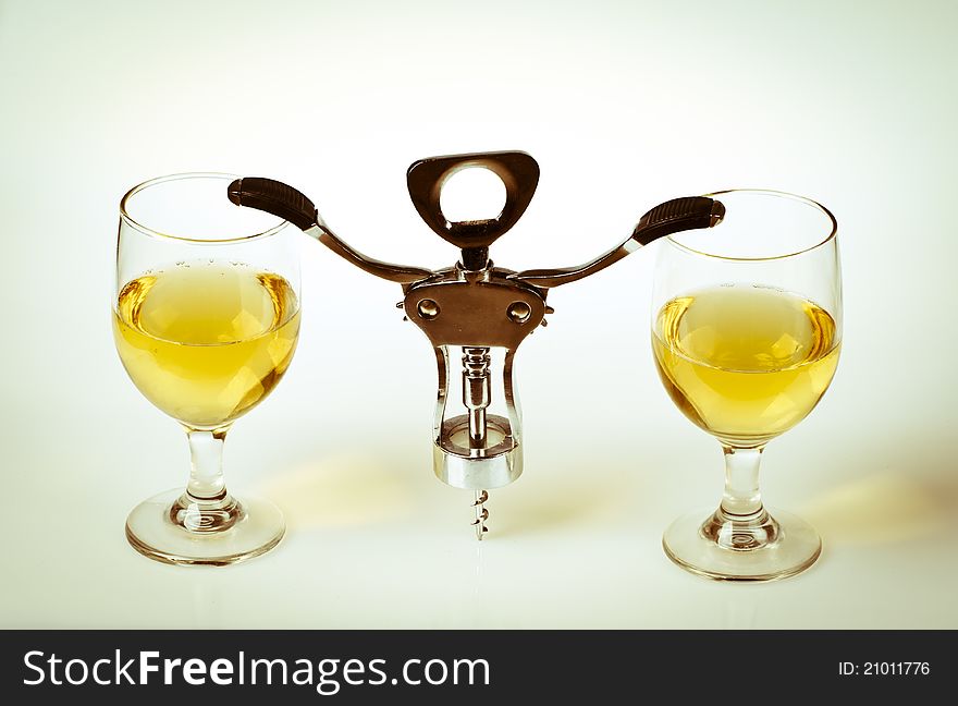 Glass of white wine and corkscrew isolated on a white background. Glass of white wine and corkscrew isolated on a white background