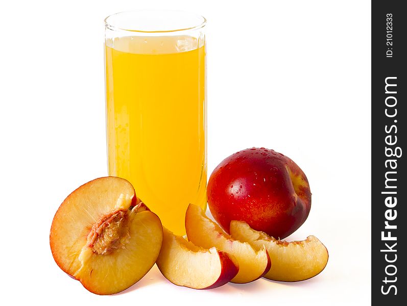 Peach juice in glass with peaches around it