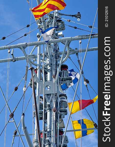 Frigate with signal flags against the blue sky