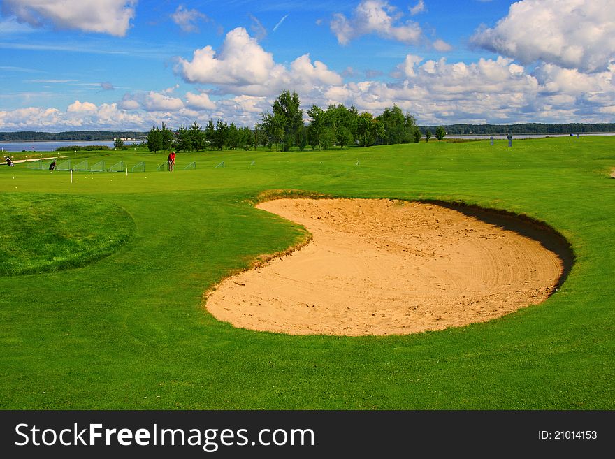 Sand course with green grass and blue sky. Sand course with green grass and blue sky