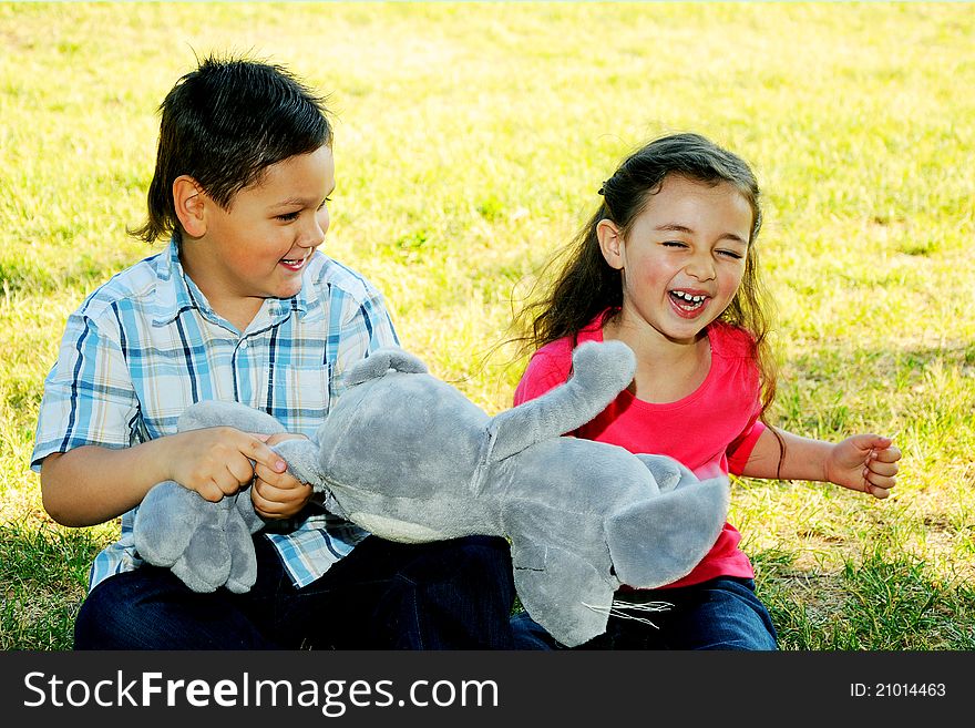 The boy with the girl play sitting on a grass in park