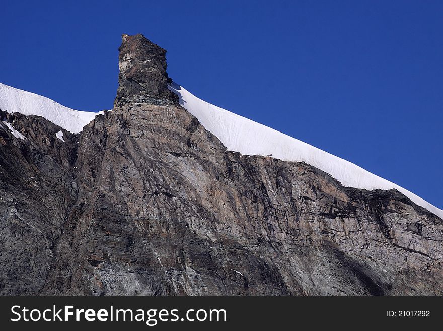 The rocky Feechopf ridge with its peak situated in Pennine Alps near Saas Fee in Switzerland. The rocky Feechopf ridge with its peak situated in Pennine Alps near Saas Fee in Switzerland.
