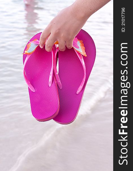 Young woman on the beach with colorful flip flop. Young woman on the beach with colorful flip flop
