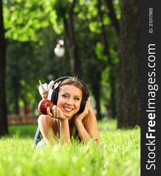 Woman with headphones listening music on the grass