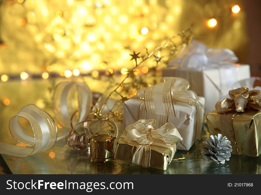 Close-up of gift boxes and twinkle lights on golden background. Close-up of gift boxes and twinkle lights on golden background