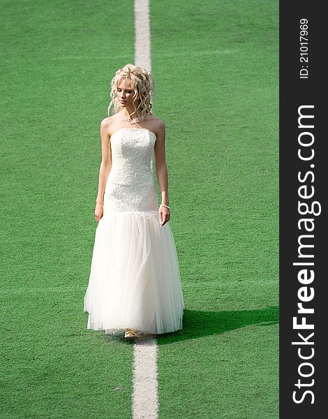 Bride on the football field with green grass. Bride on the football field with green grass