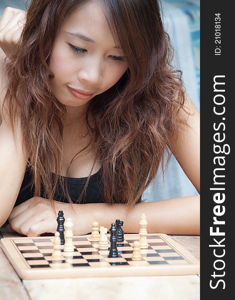 Asian woman playing chess at outdoor