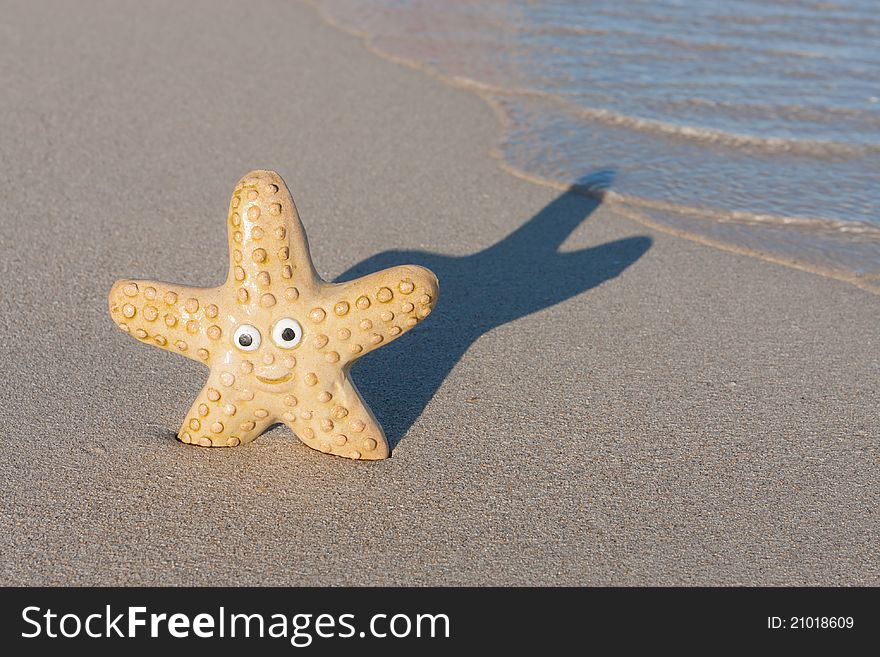 Smiling starfish with victory sign on the beach