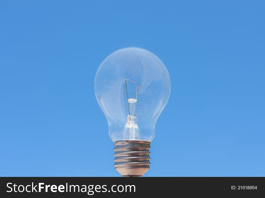 Single light bulb in blue sky. Single light bulb in blue sky