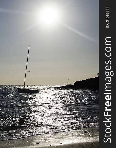 Sailing boat after sunrise in back-light, shooting from the beach. Sailing boat after sunrise in back-light, shooting from the beach