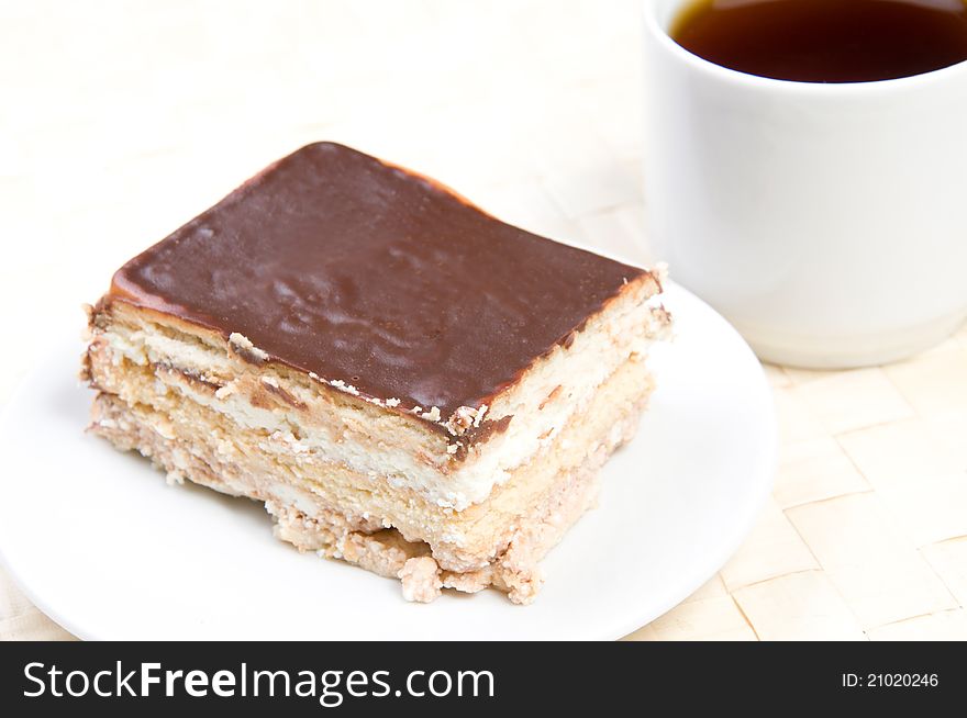 Handmade cake on plate with cup of tea