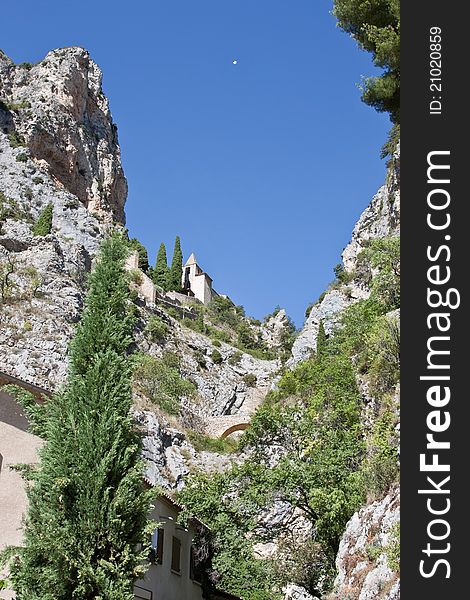 The mountain chapel at Moustier Sainte Marie, France with its star suspended between the cliffs